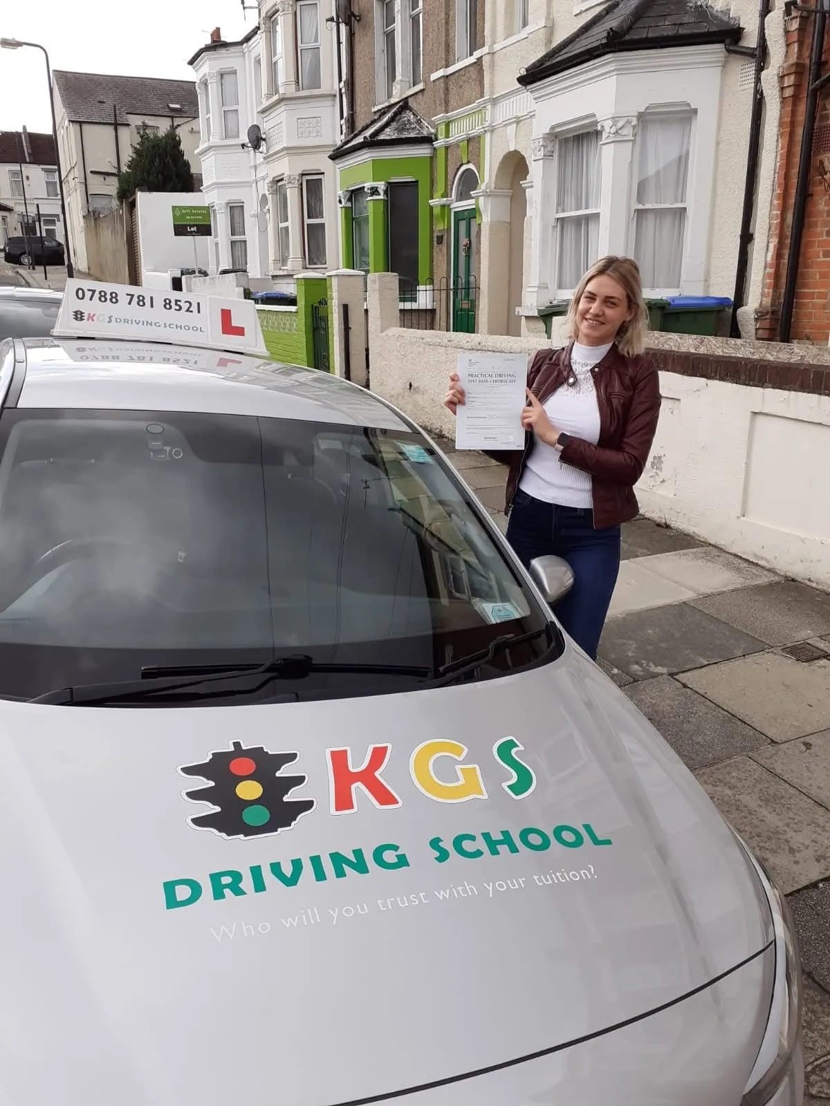 Pupil from Plumstead with her pass certificate next to the KGS Driving School car