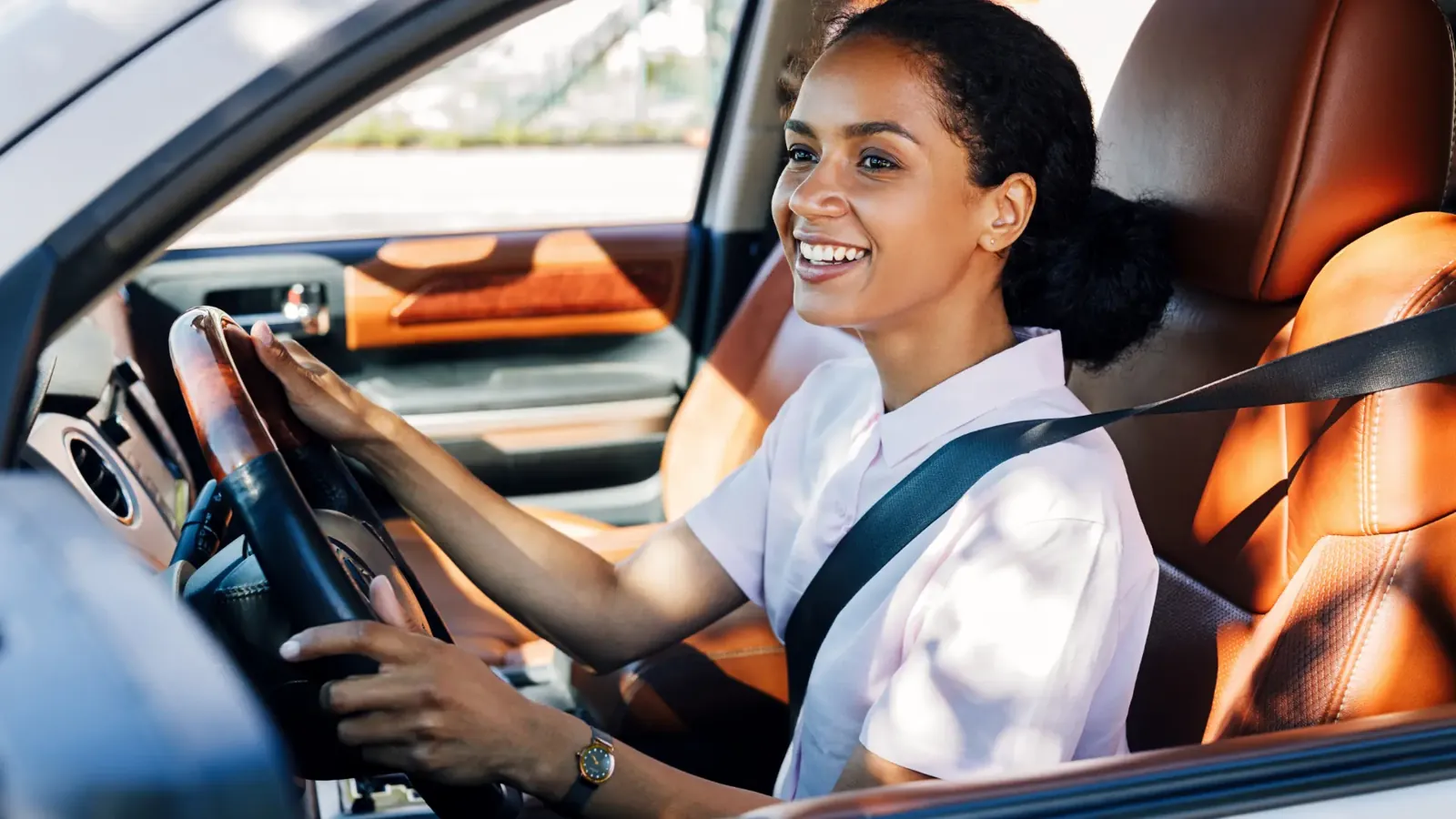Newly qualified driver smiling behind the wheel on a Pass Plus lesson