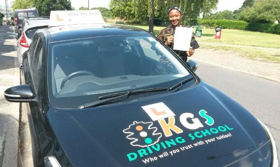 Pupil with her pass certificate beside the KGS Driving School car