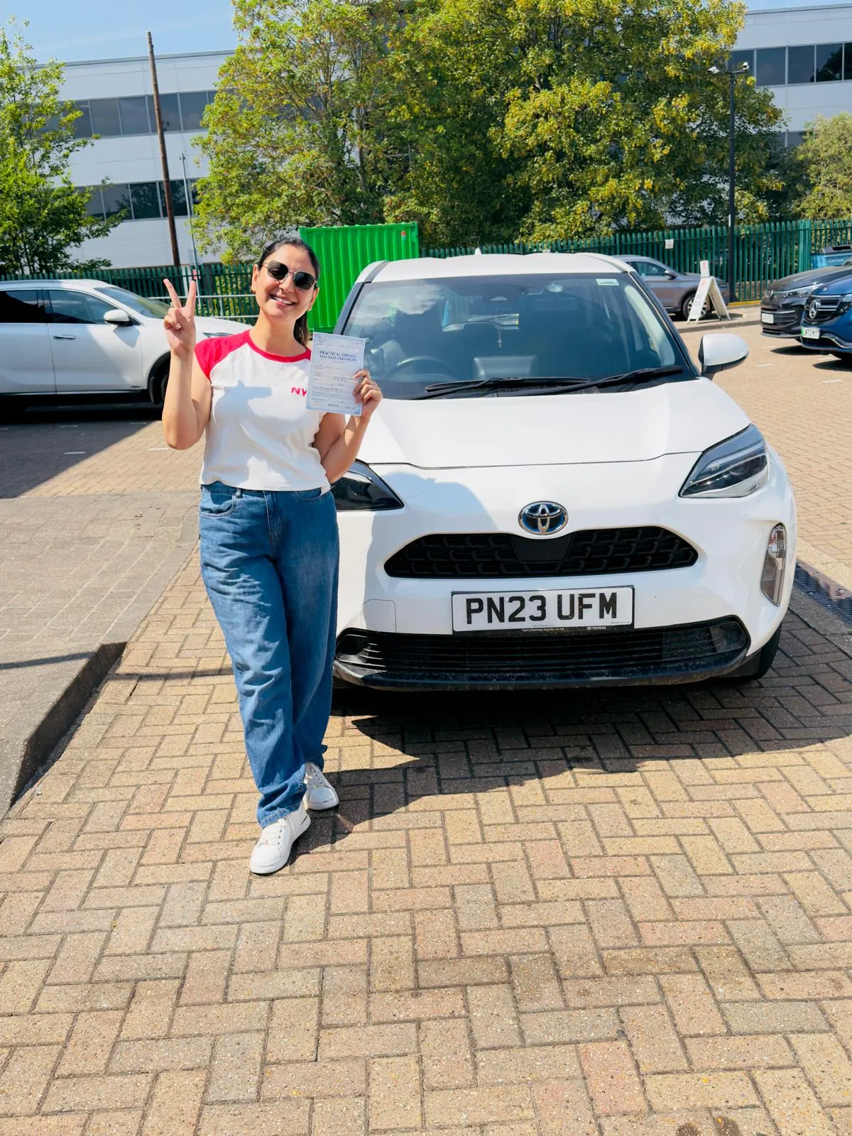 Pupil celebrating her driving test pass with her pass certificate