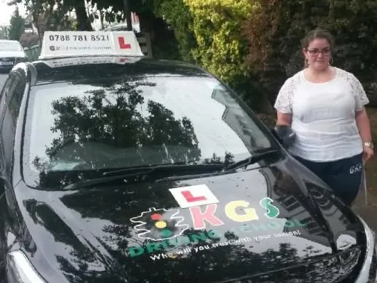 Pupil standing beside the KGS Driving School car